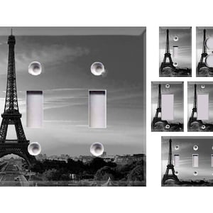 May include: A set of light switch covers featuring a black and white photograph of the Eiffel Tower in Paris, France. The covers are available in single, double, and triple switch configurations.