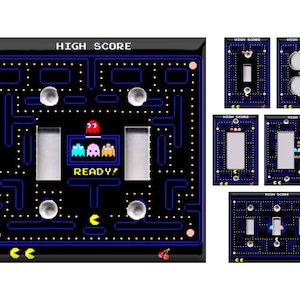 May include: A set of light switch and outlet covers featuring a Pac-Man maze design with the text "HIGH SCORE" and the characters Pac-Man, Blinky, Pinky, and Inky. The covers are black with blue and yellow accents.