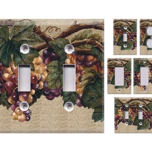 May include: A set of light switch covers featuring a vintage illustration of grapes hanging from a vine. The design is on a beige background with green leaves and purple and yellow grapes.