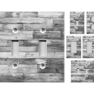 May include: Set of light switch and outlet covers featuring a rustic wood plank design in shades of gray. The covers are designed to fit standard light switches and outlets.