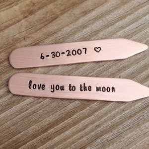 May include: Two copper-colored tie bars with engraved text. The top bar reads "6-30-2007" with a heart symbol. The bottom bar reads "love you to the moon".