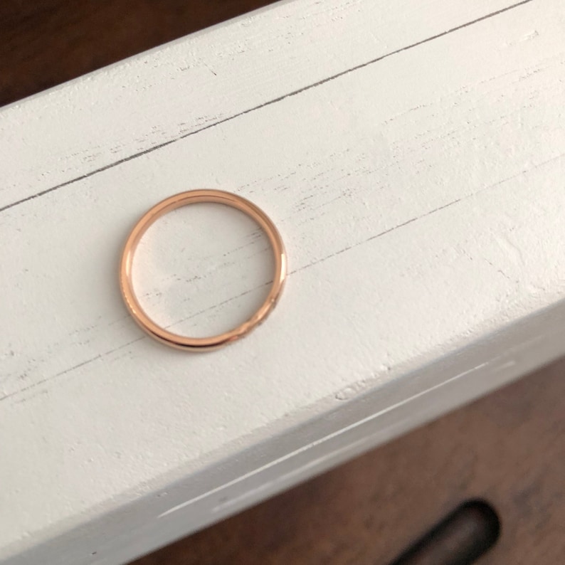 Peut inclure: Une simple bague en or rose. La bague est lisse et a une finition polie.