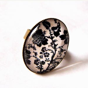 Bague, en bronze, cabochon ovale fleurs noires sur fond beige2 . Anneau ajustable. Rétro et chic. image 1