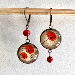 Asymmetrical earrings with poppies and vintage romantic writing, dangling in bronze.