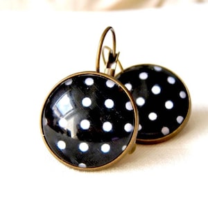 Earrings sleepers retro cabochons on a black background bronze white peas and glass.