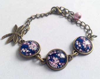 Bracelet fleurs de sakura sur fond bleu, cabochon en verre, libellule et perle, chaîne en bronze.