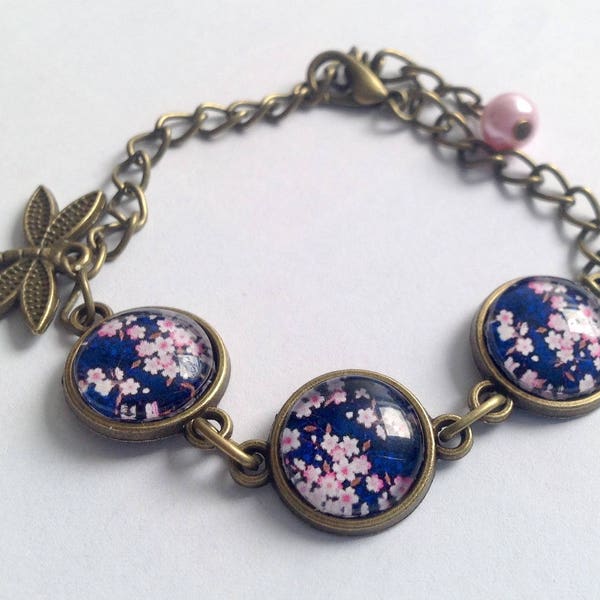 Bracelet fleurs de sakura sur fond bleu, cabochon en verre, libellule et perle, chaîne en bronze.