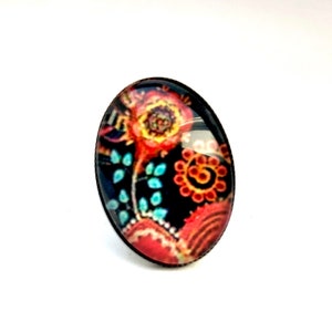 Oval cabochon earrings, stylized flowers on a dark background, mid-length. Bague