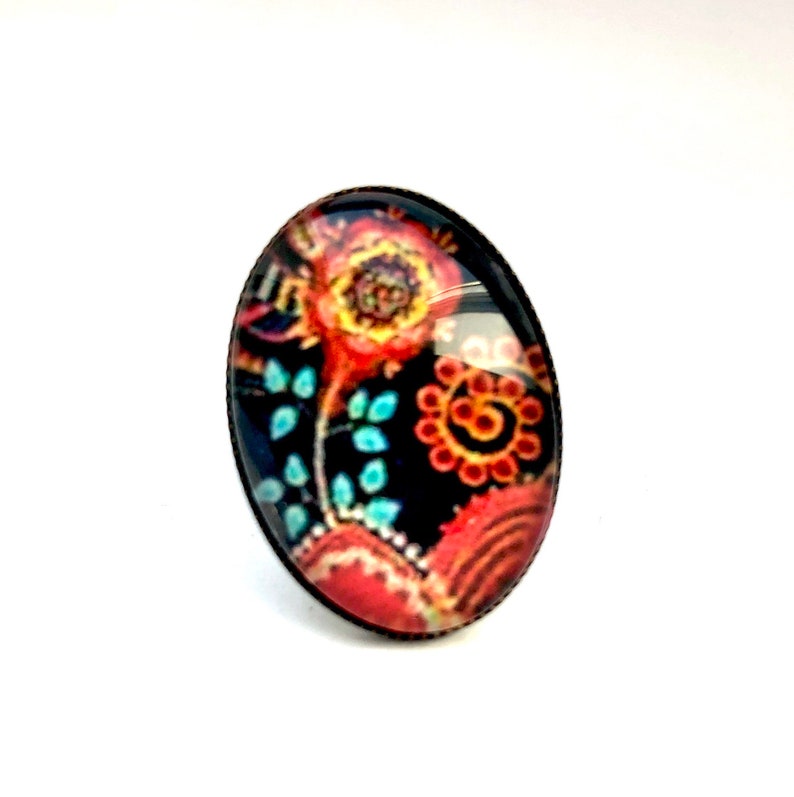 Oval cabochon earrings, stylized flowers on a dark background, mid-length. Bague