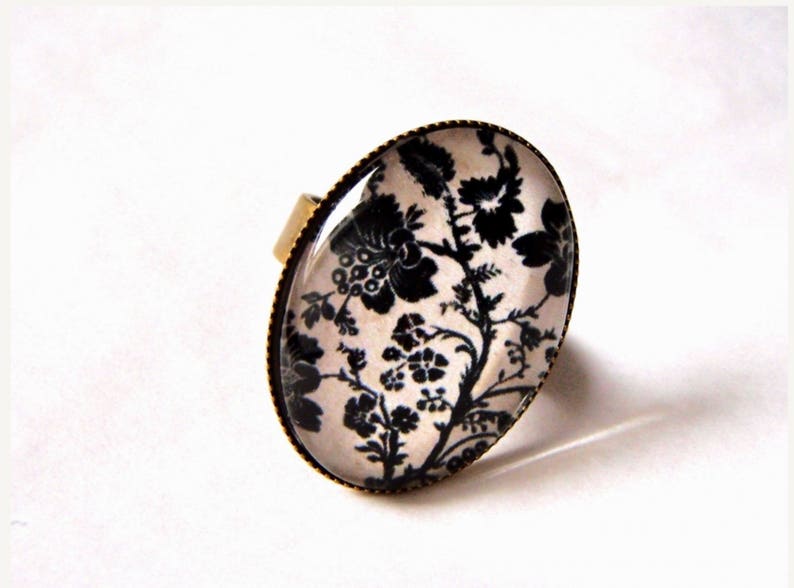 Bague, en bronze, cabochon ovale fleurs noires sur fond beige2 . Anneau ajustable. Rétro et chic. image 1