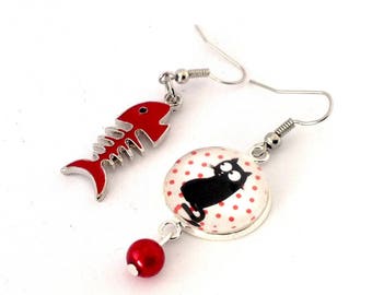 Boucles d'oreille asymétriques pendantes : chat noir sur fond blanc à pois rouges et poisson rouge.