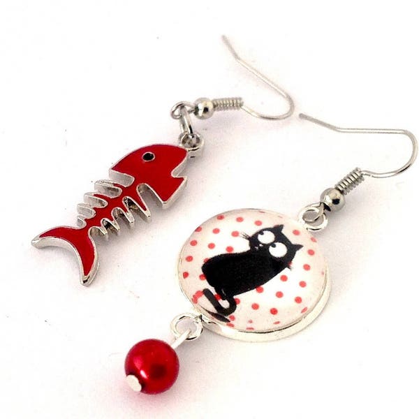 Boucles d'oreille asymétriques pendantes : chat noir sur fond blanc à pois rouges et poisson rouge.