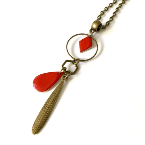 Collier, sautoir, avec un pendentif en losange rouge et breloques.