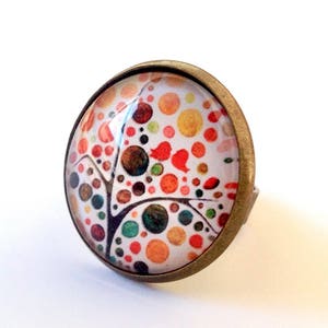 Large tree of life cabochon ring in orange, yellow, brown tones.