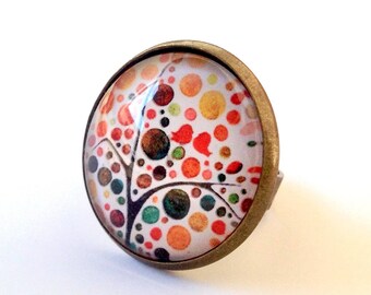 Large tree of life cabochon ring in orange, yellow, brown tones.