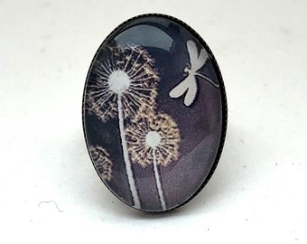 Oval ring: dandelions and dragonfly on a gray background, in bronze.