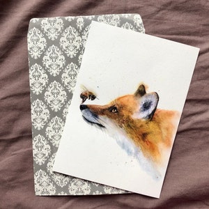 May include: A watercolour painting of a fox with a bee flying in front of its nose. The fox is looking at the bee with a curious expression. The painting is done in shades of brown, orange, and yellow.