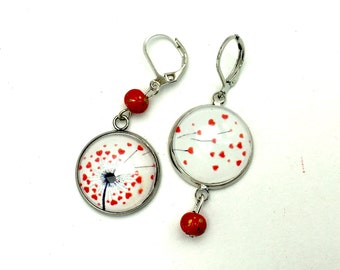 Asymmetrical dandelion earrings and a flight of red hearts, pearls, silver metal.