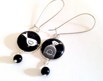 Boucles d'oreilles pendantes, cabochon oiseau et cage, noir et blanc, métal argenté, perles noires.