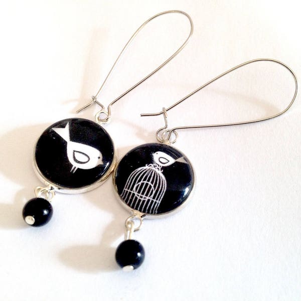 Boucles d'oreilles pendantes, cabochon oiseau et cage, noir et blanc, métal argenté, perles noires.