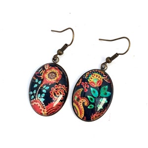 Oval cabochon earrings, stylized flowers on a dark background, mid-length. Pendantes