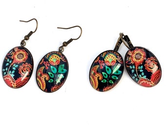 Boucles d’oreilles cabochons ovales, fleurs stylisées sur fond sombre, mi-long.