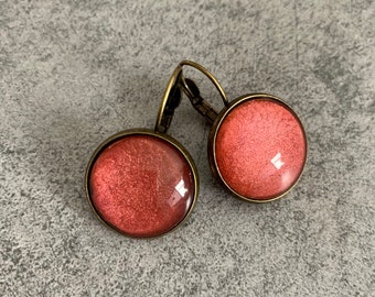 Boucles d'oreille dormeuses monochrome rouge irrisé, en métal bronze ou acier inoxydable et cabochon en verre.