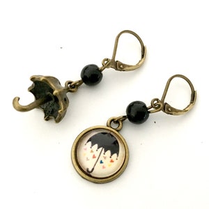 Small mismatched dangling umbrella earrings and black pearls.