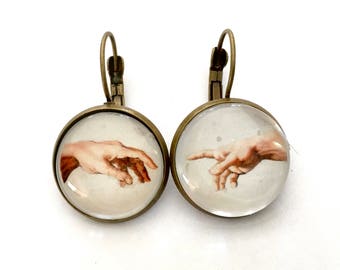 Leverback earrings, cabochons: detail of Michelangelo's creation of Adam. Bronze and glass.