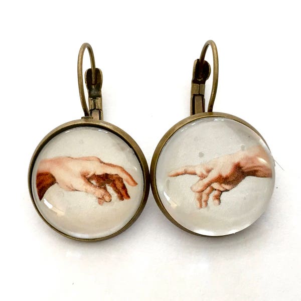 Boucles d’oreilles dormeuses, cabochons : détail de la création d’Adam de Michel-Ange. Bronze et verre.