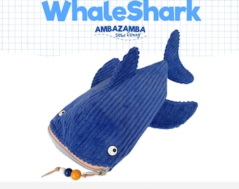 Könnte beinhalten: Ein blaues Walhai-Federmäppchen aus Kord mit Reißverschluss und einer Kordel mit drei bunten Perlen. Der Text lautet Pencil Case WhaleShark AMBAZAMBA sew funny und PDF Sewing Pattern vor einem Hintergrund mit Karomuster.