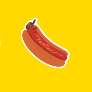 May include: A cartoon hot dog with a smiling face wearing a baseball cap with the letter "N" on it. The hot dog is labeled "Carolina".