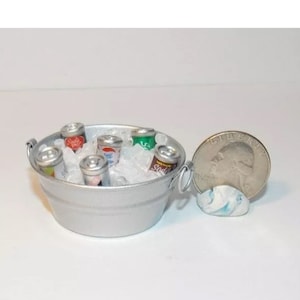 May include: A miniature silver metal tub filled with ice and six miniature cans of soda. The cans have different colored labels with the word "Soda" on them. A US quarter is shown for scale.