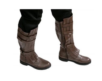 May include: A pair of brown leather boots with buckles and straps. The boots are knee-high and have a pointed toe.