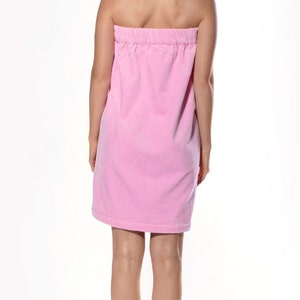 May include: A pink terry cloth wrap dress with a gathered waist.