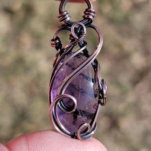 May include: A white ceramic mug with a black handle and the text "But First, Coffee" in a black, handwritten-style font. The mug is on a white surface.