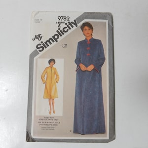 May include: Vintage Simplicity sewing pattern envelope. The envelope features a woman in a long blue robe with red trim and buttons. A smaller image shows a yellow robe. The text on the envelope reads "Jiffy Simplicity".