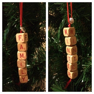 May include: Two Christmas ornaments made from wooden blocks with the words "FAMILY" and "WINTER" spelled out in red letters.
