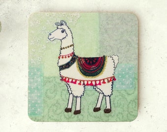 May include: A white llama with a colorful saddle and tassels on a green and blue patterned background. The llama is standing on a light green background.