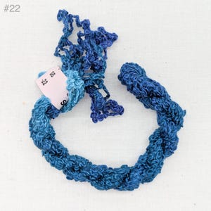 May include: A skein of blue and teal embroidery floss with a tag that reads "#22 S88".