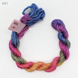 May include: A skein of multi-colored yarn with shades of blue, purple, pink, orange, yellow, and green. The yarn is labeled "SSS - 41".