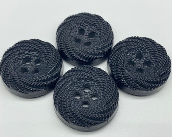 Può includere: Quattro bottoni in plastica nera con un design in rilievo testurizzato a forma di corda. Ogni bottone ha quattro fori.