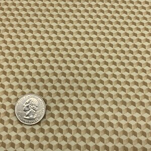 May include: Beige fabric with a repeating pattern of brown 3D cubes.