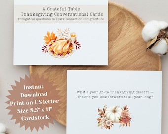 May include: Two white Thanksgiving conversational cards. One card reads "A Grateful Table Thanksgiving Conversational Cards" with a turkey illustration. The other card asks "What's your go-to Thanksgiving dessert?" with a pumpkin illustration.