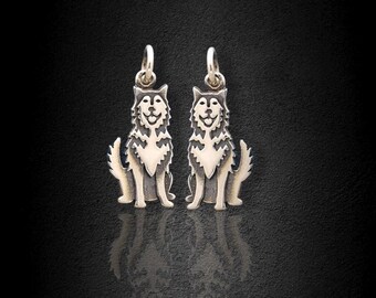 May include: Two silver charms in the shape of a sitting wolf. The wolves are facing forward with their tails curled behind them. The charms are detailed with a black and white design.