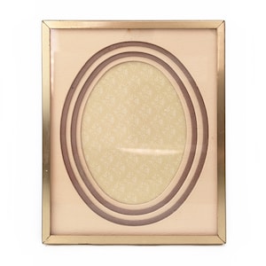 May include: A gold-colored picture frame with a cream-colored mat and a triple oval opening. The mat has a subtle floral pattern.