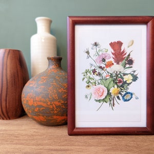 May include: A framed print of a vintage botanical illustration featuring a colorful bouquet of flowers in shades of pink, red, yellow, blue, and white. The frame is a dark wood color.