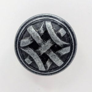 May include: A silver and black round cabinet knob with a woven design.