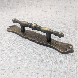 May include: A set of three ceramic mugs with a speckled, matte finish. The mugs are in shades of cream, light gray, and dark gray. Each mug has a simple, minimalist design and a rounded handle.