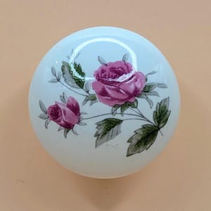 May include: White ceramic knob with a pink rose floral design.